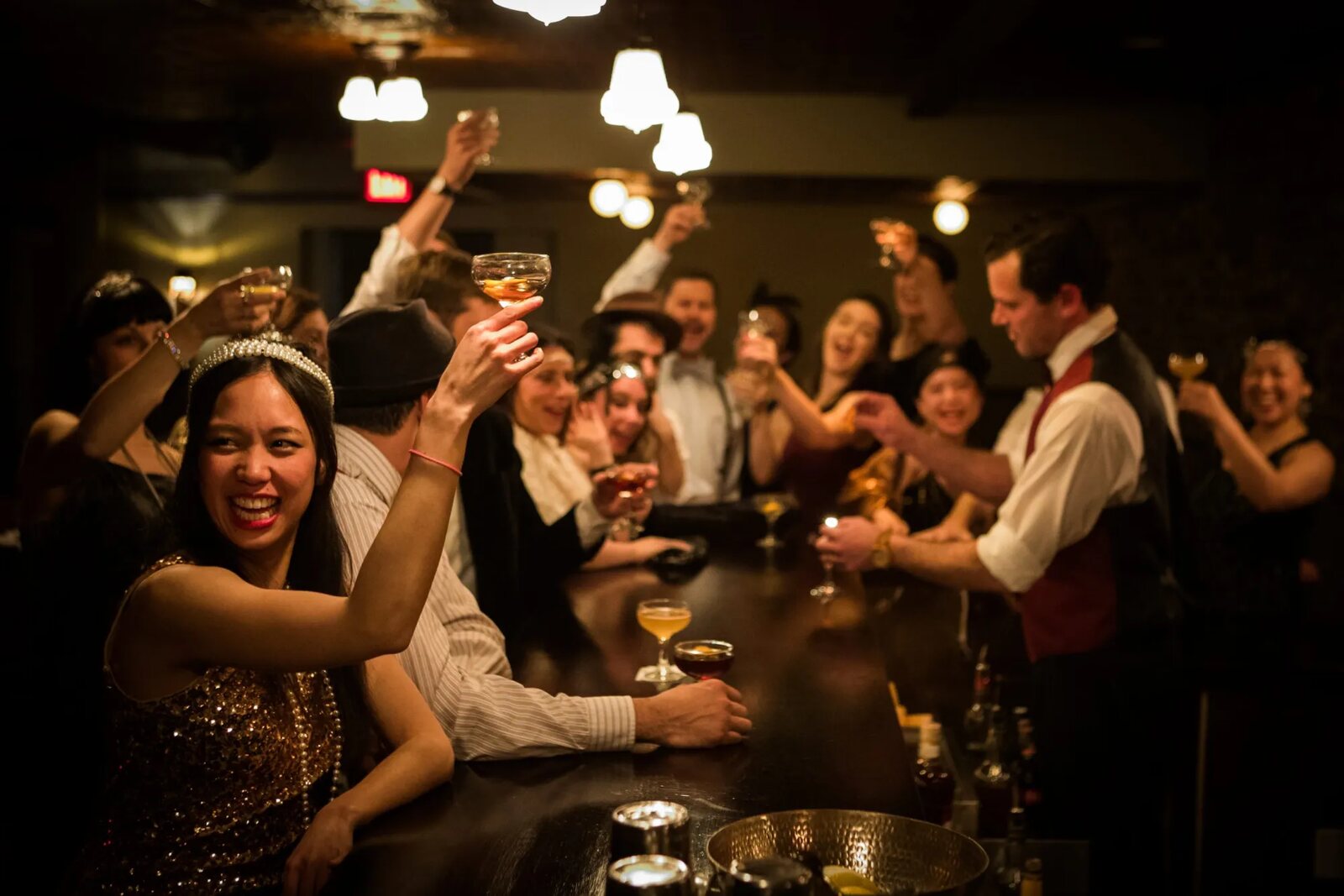 Guests raising a toast at the bar of The Speakeasy